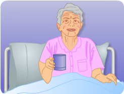Jean lying upright in a hospital bed with a hot drink.