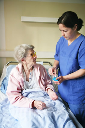 A nurse attending to a patient, who is lying in bed