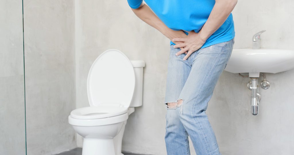 man with urine urgency in the toilet